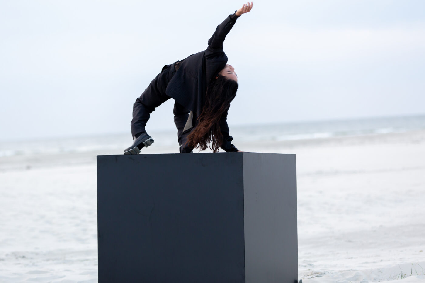 Een dansers op een zwart blok in de theatervoorstelling SLEEEP DREEEAM WAKEEE van Het Atelier en Lucinda Wessels tijdens Oerol 2022.