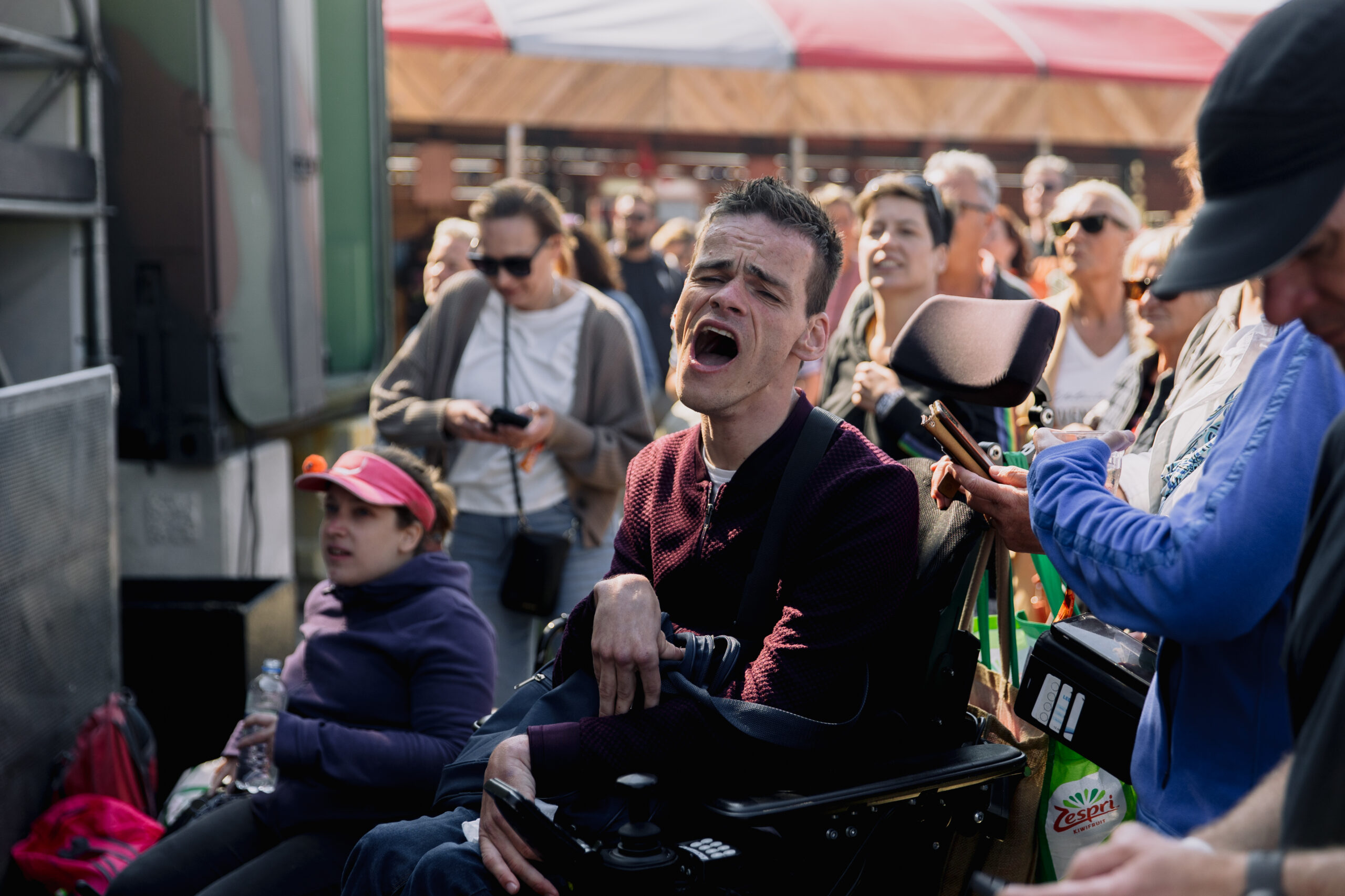 Spastische man in rolstiel zingt mee met optreden op festivalhart de Deining, Oerol 2023
