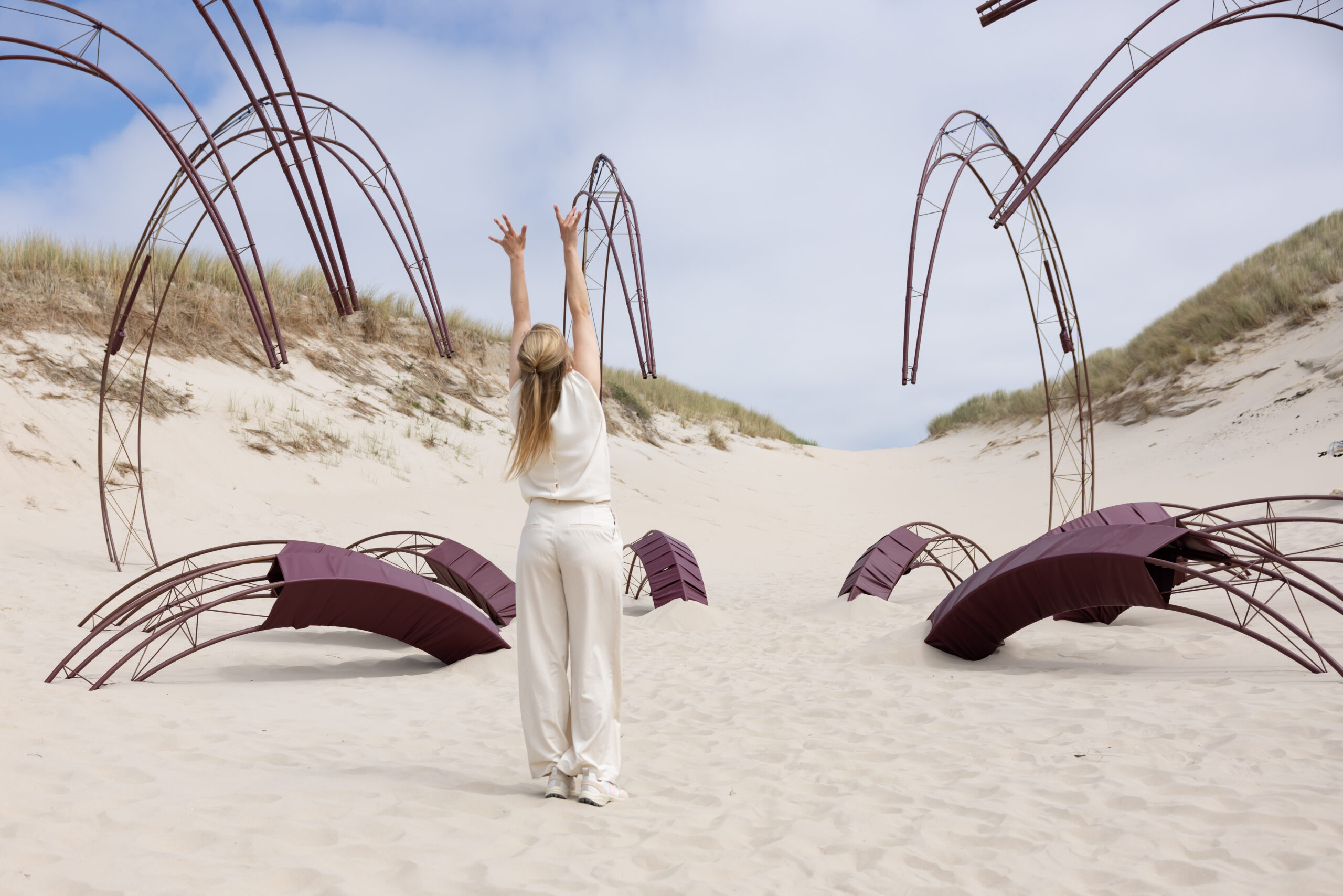 Acteur Eva Meijering staat in het decor van acht grote stalen constructies die de poten van een octopus uitbeeld in de theatervoorstelling Sâlt over de strijd met jezelf en de scheiding tussen lichaam en geest, Oerol 2023