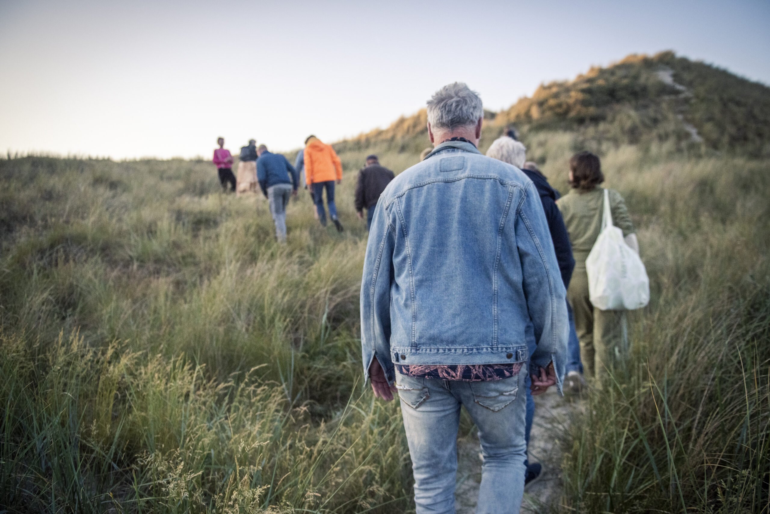 Publiek op weg naar het Huisfeest, een performance van Collectief Walden tijdens Oerol Festival 2023