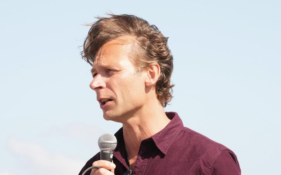 Portret van Siart Smit die een speech houdt, terwijl de wind zijn haren omhoog waait.