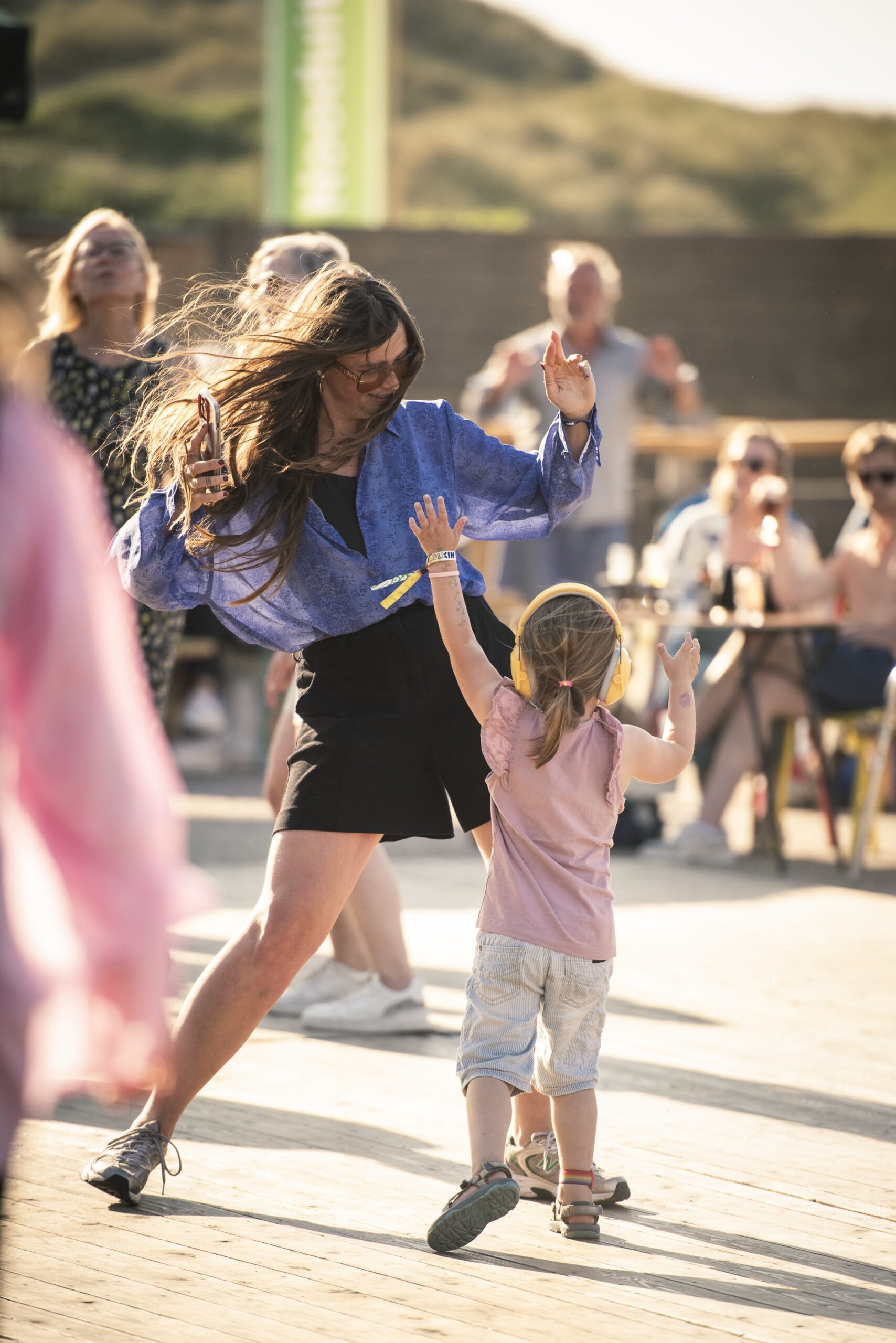 Moeder en dochter dansen op de muziek van Rizan Said op festivalhart de Deining tijdens Oerol 2023.