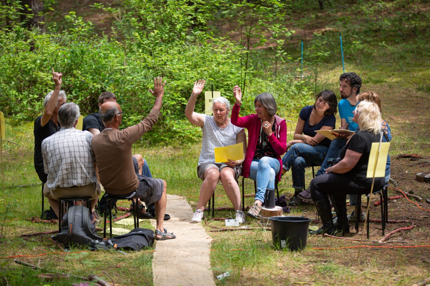 Mensen stemmen door hun hand op te steken tijdens het residentieproject van Emke Idema gespeeld op Oerol 2019.