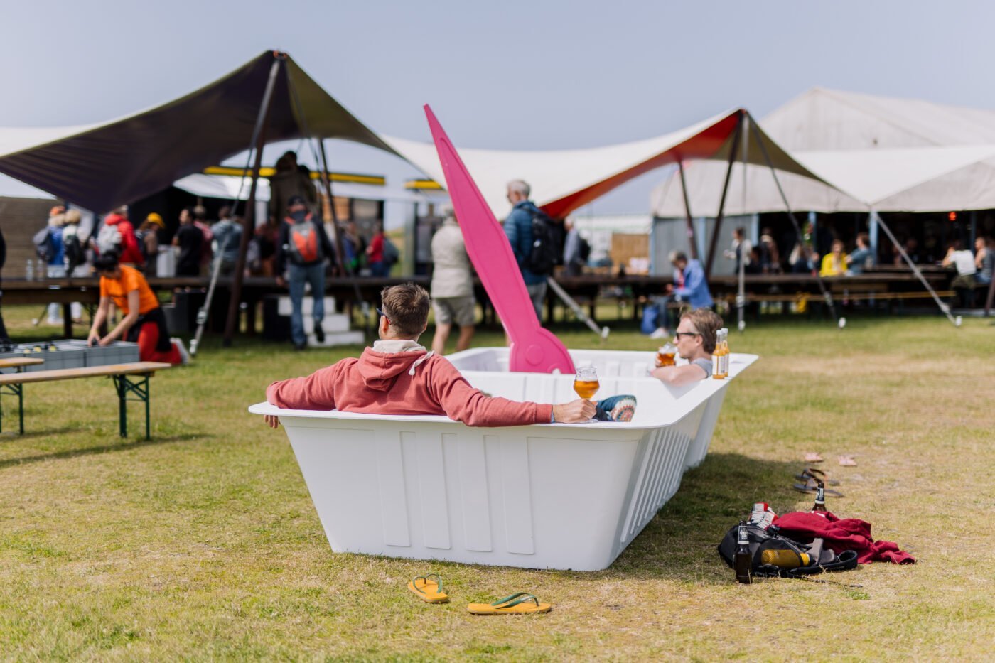 Twee mannen chillen in een levensgroot plastic frietbakje, een installatie van Tryater, waarbij het publiek individueel plaatsneemt in een levensgroot patatbakje en luistert naar een compilatie van fragmenten waarin mensen vertellen over hun drift om te consumeren en het geluk dat ze daaraan ontlenen, Oerol 2022