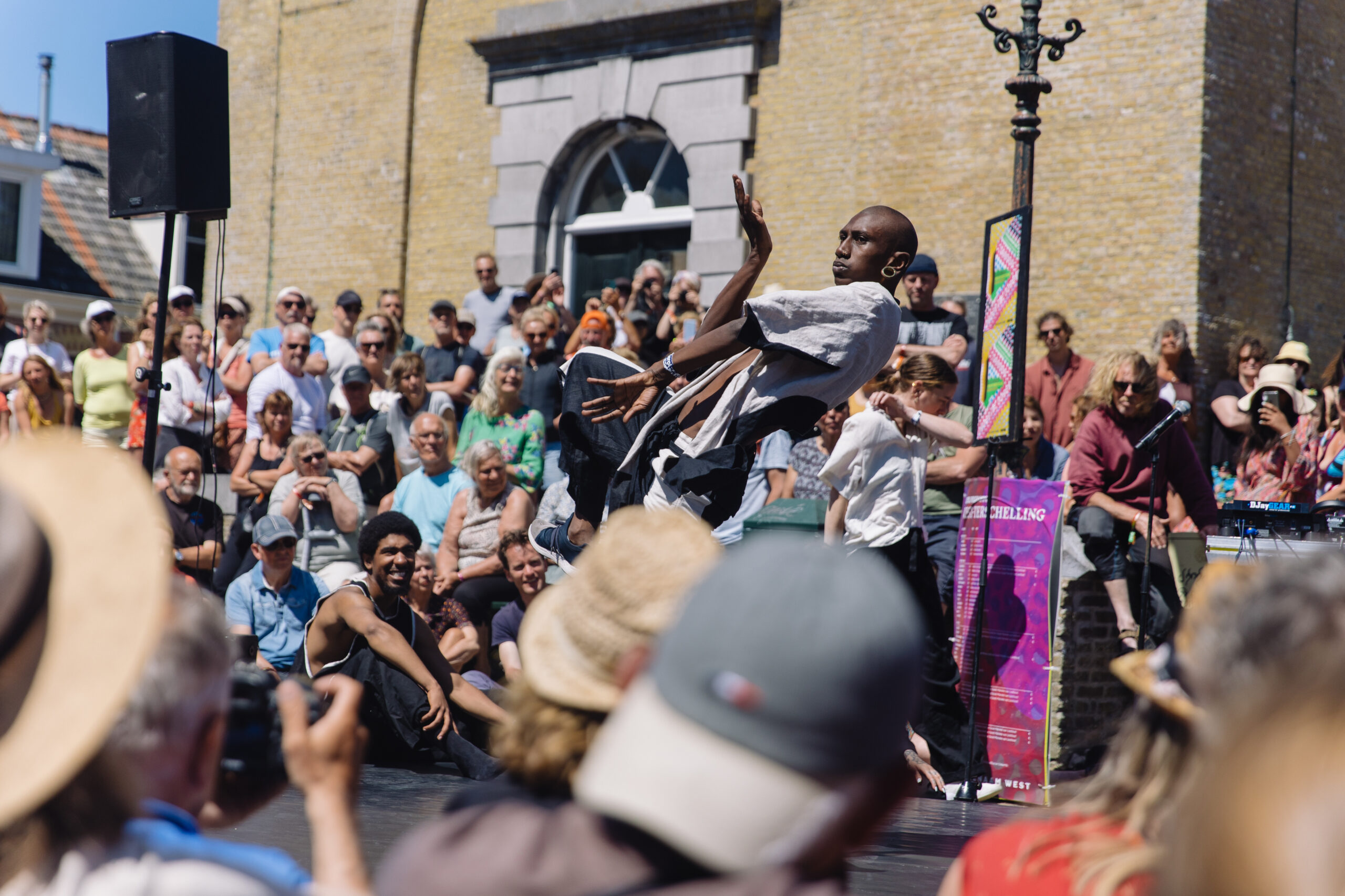 Danser Gil the Grid tijdens een straattheatervoorstelling aan de voet van de Brandaris tijdens Oerol 2023