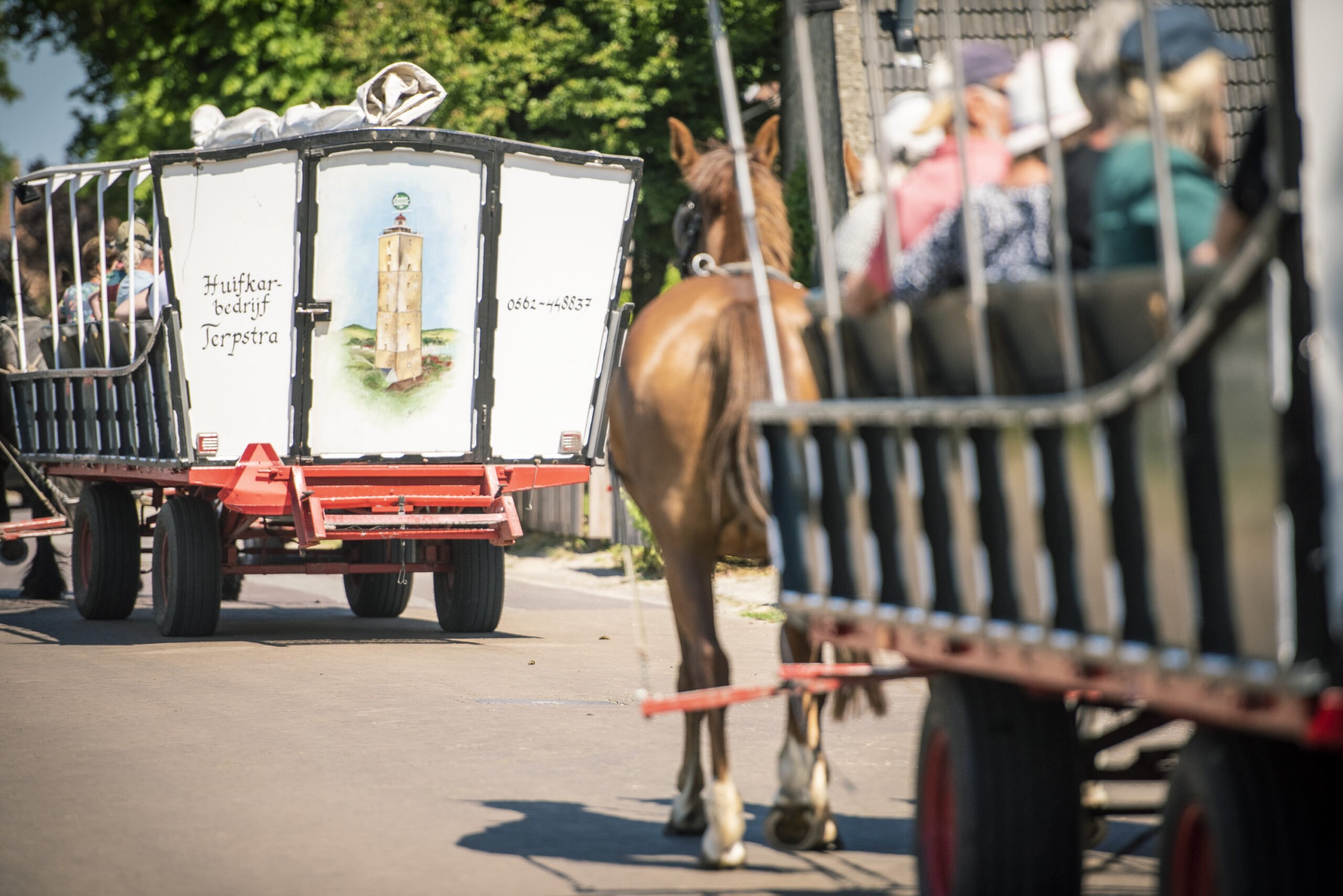 Twee huifkarren vol mensen die op 'e riid gaan bij een Vriendenactie tijdens Oerol 2023