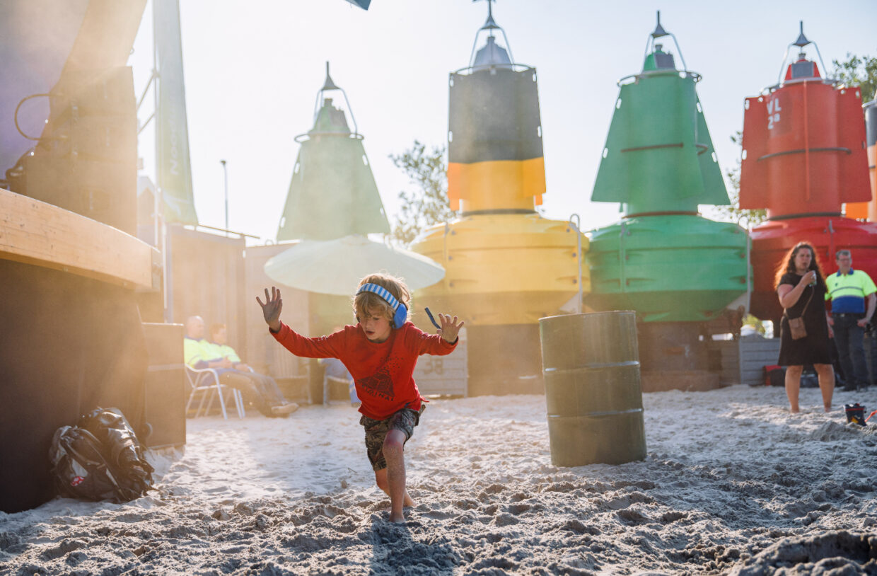 Kind dans met koptelefoon op op festivalterrein de Betonning tijdens Oerol 2022