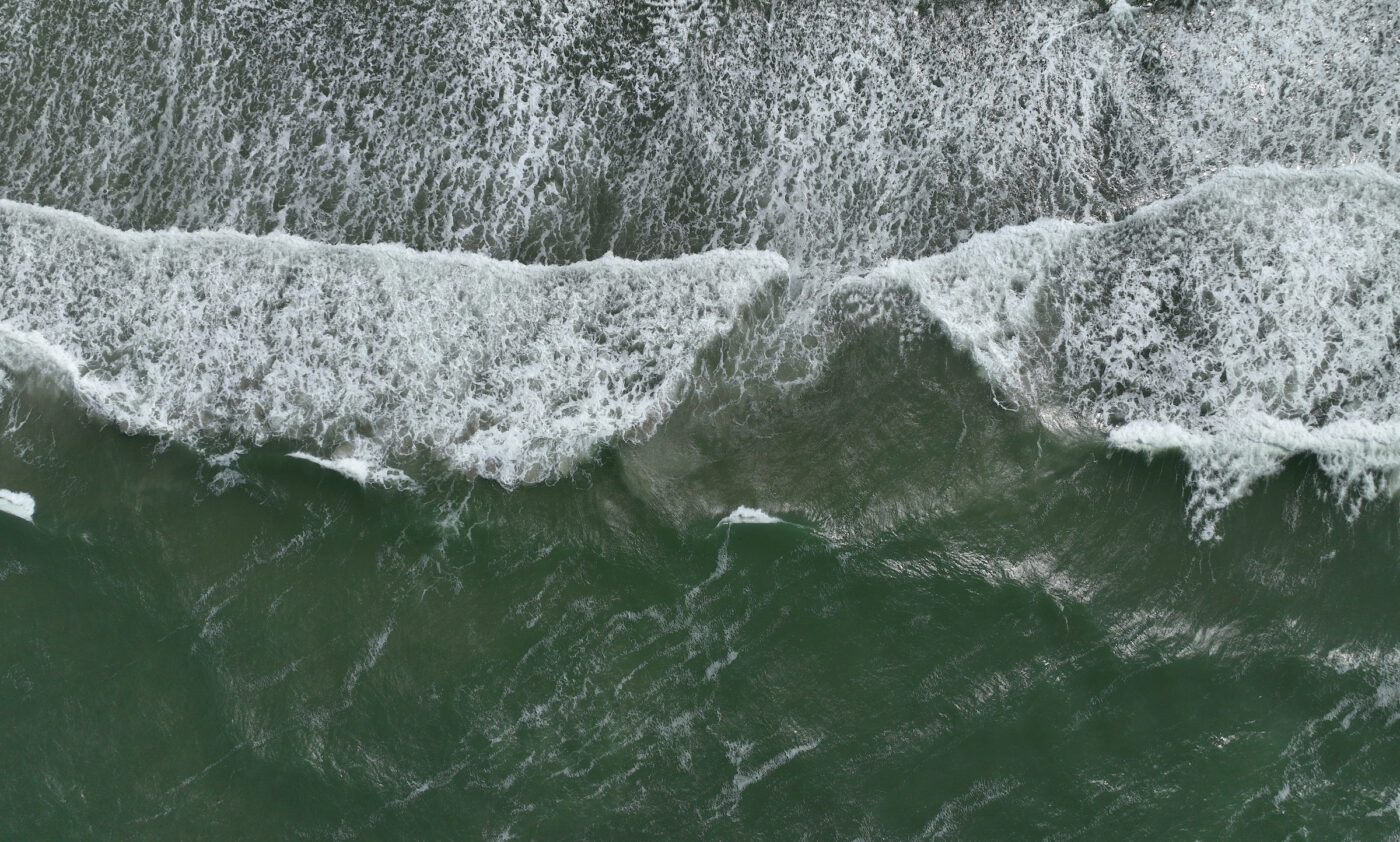 Een foto van de branding van de Noordzee van bovenaf