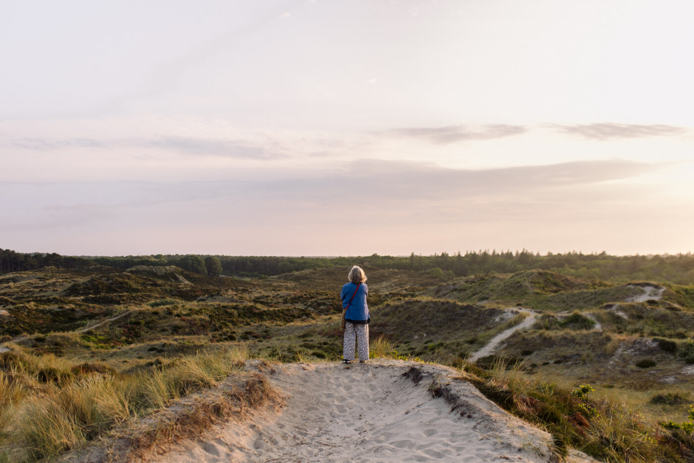 Vrouw staart over het wijdse landschap van Terschelling